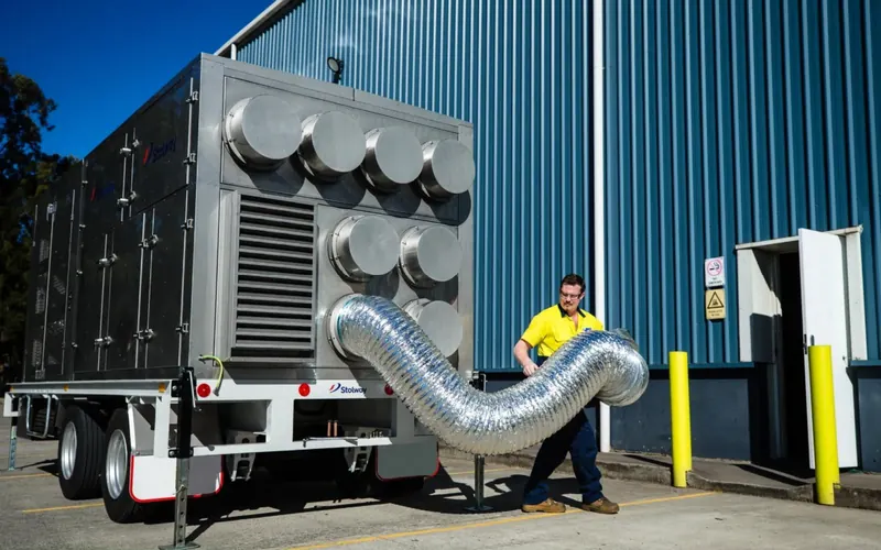 Stolway engineer connecting ducting to a trailer-mounted mobile HVAC unit